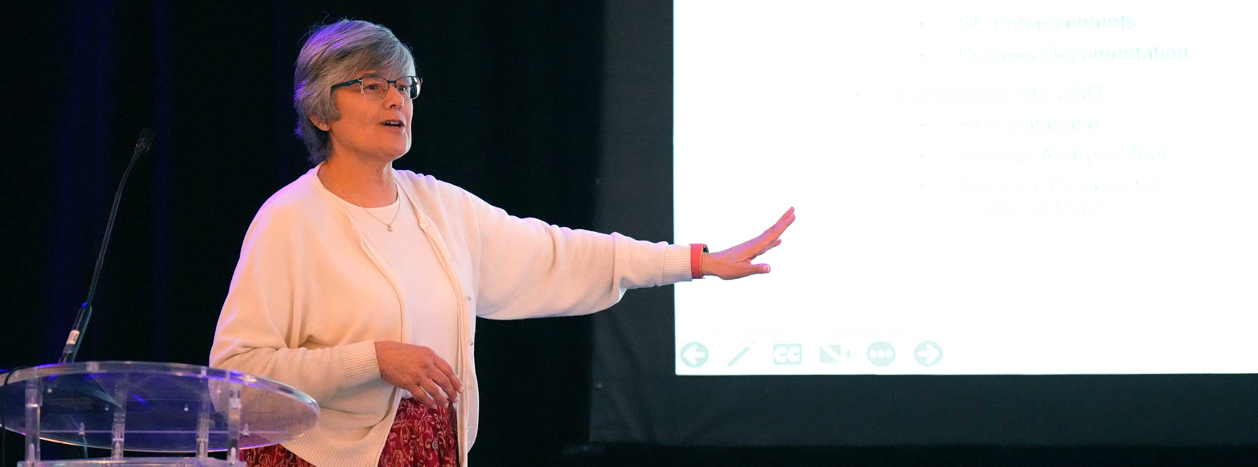 Sheela Andrews giving a presentation on a stage